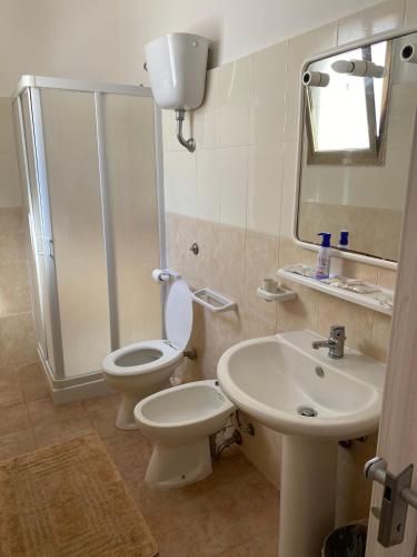 a bathroom with a toilet and a sink and a shower at Cimalù by Lampara in Torre San Gennaro