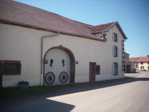 a white building with a large door on the side of it at Grange d'Anjeux Bed & Breakfast in Anjeux