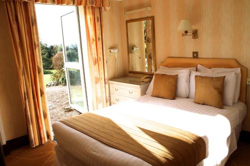 
a bedroom with a large bed and a large window at The Devoncourt Resort in Exmouth
