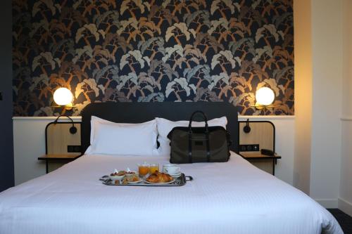 a tray of food sitting on top of a bed at Hôtel Anne d'Anjou, The Originals Collection in Saumur