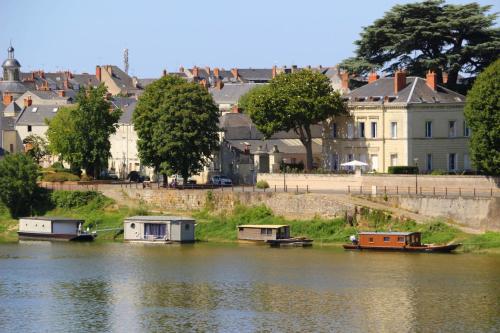 a group of boats on the water in a town at Hôtel Anne d'Anjou, The Originals Collection in Saumur