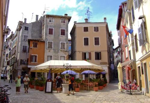 a group of people walking down a street with umbrellas at Apartment Matteotti 199 in Rovinj