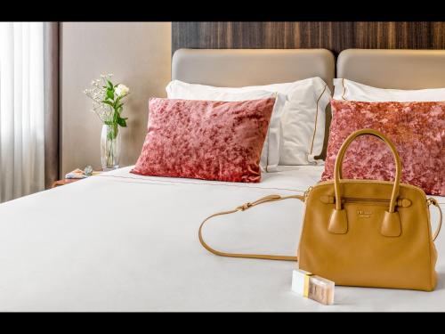 a tan bag sitting on a bed with pillows at Hotel Moon & Sun Porto in Porto