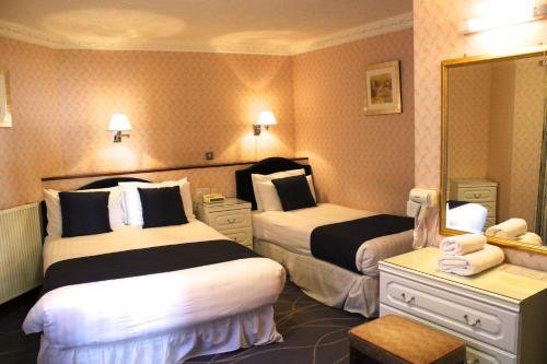 
a hotel room with two beds and two lamps at The Devoncourt Resort in Exmouth
