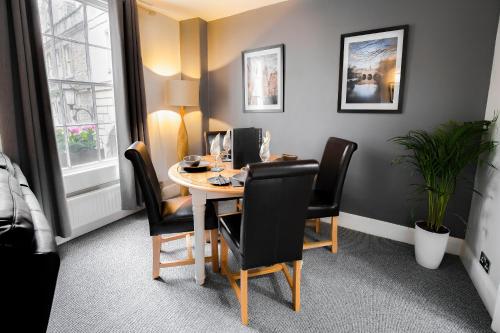 a room with a table with chairs and a computer on it at The Green Leaf Apartment in Bath