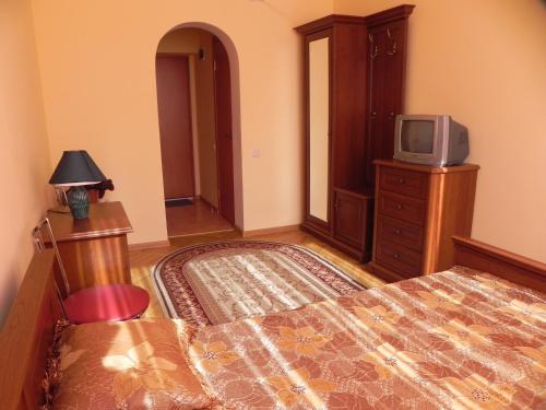a bedroom with a bed and a tv on a dresser at Blaz in Odesa