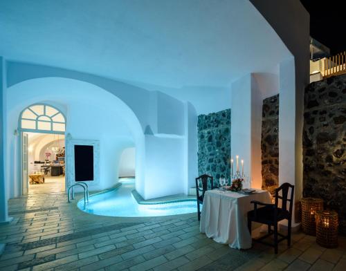 Habitación con mesa y luz azul en Nefeles Luxury Suites, en Fira