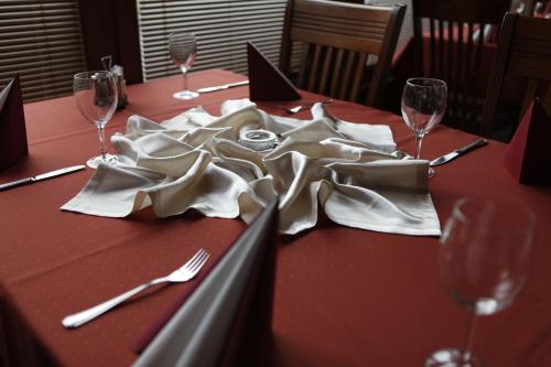a table with forks and napkins on a table with wine glasses at Hotel Europa in Liptovský Mikuláš