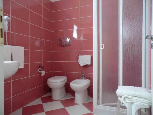 a red bathroom with a toilet and a sink at Mediterraneo Mare e Sole in Marina di Palma