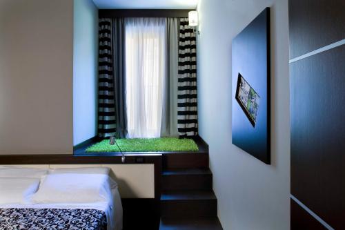 a small bedroom with a bed and a window at Best Western Cinemusic Hotel in Rome