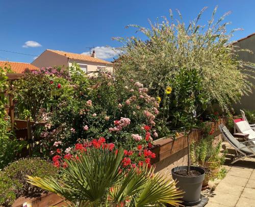 a garden with flowers and plants on a fence at Les portes du soleil in Les Sables-d'Olonne