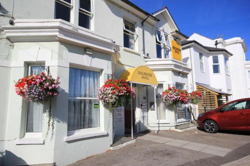 a white building with flower baskets on the front of it at Dolphins Hotel in Bournemouth