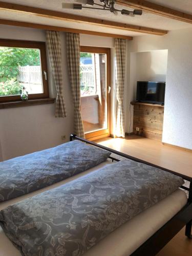 a bedroom with a bed and a television in it at Seealm in Döbriach