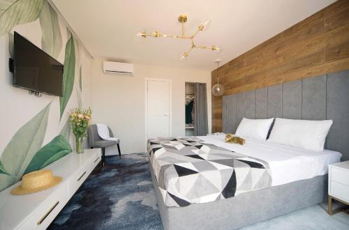 White Villas Koblevo في كوبليفو: غرفة نوم بسرير كبير وتلفزيون