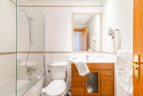a bathroom with a toilet and a sink and a mirror at Calas Beach Corralejo in Corralejo