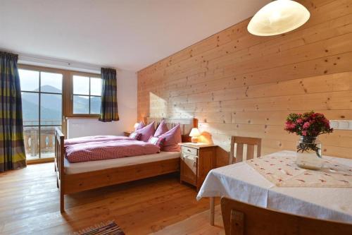 Schlafzimmer mit einem Bett und einem Tisch mit einem sidx sidx sidx in der Unterkunft Apartement Vorderlaiming in Söll