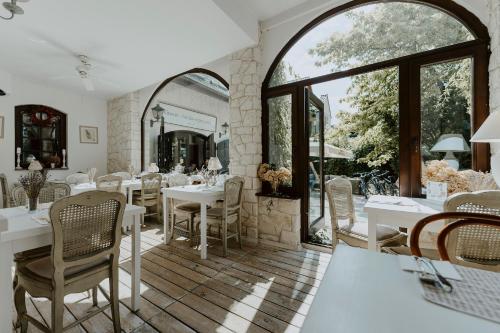 a dining room with tables and chairs and a large window at Vincent in Kazimierz Dolny