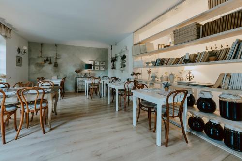 a dining room with white tables and wooden chairs at Vincent in Kazimierz Dolny