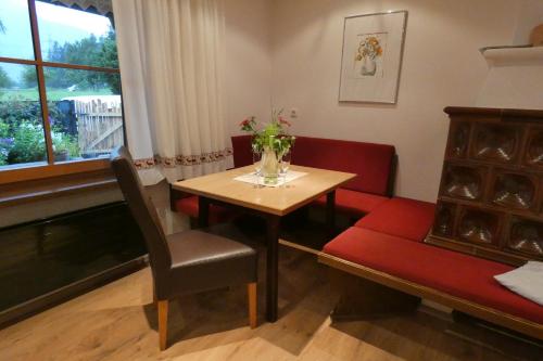 a dining room with a table and a chair and a piano at Gästehaus Reichholf in Neukirchen am Großvenediger
