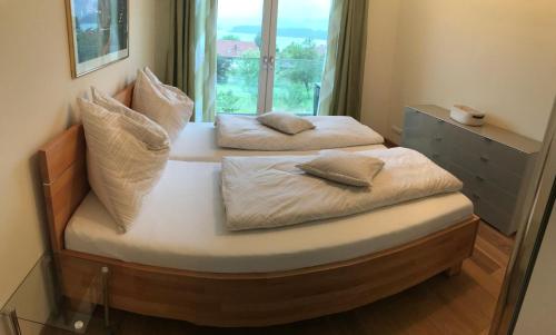 2 łóżka pojedyncze w pokoju z oknem w obiekcie Lake View Drobollach w Villach