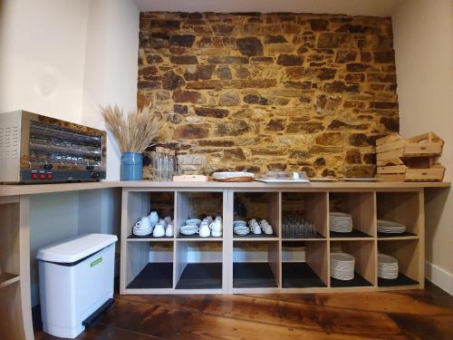 un mur en pierre avec une étagère et des chaussures. dans l'établissement Albergue Casa Cuartel, à A Fonsagrada