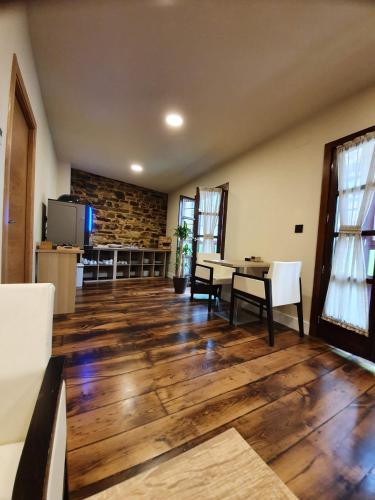 a living room with a table and chairs and a tv at Albergue Casa Cuartel in Fonsagrada