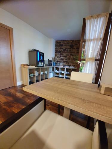 a dining room with a wooden table and chairs at Albergue Casa Cuartel in Fonsagrada