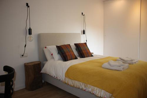 a bedroom with a bed with a yellow blanket at El 8 de Serranos in León