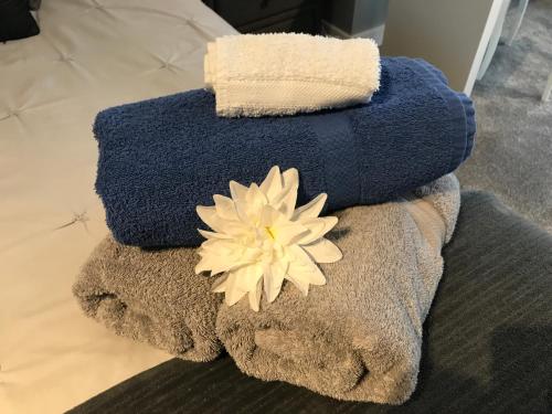 a pile of towels with a flower on top at The spinney home stay in Leamington Spa