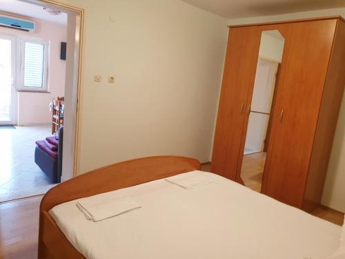 a small bedroom with a bed and a closet at BetaNovalja in Novalja