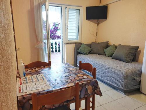 a living room with a table and a couch at BetaNovalja in Novalja