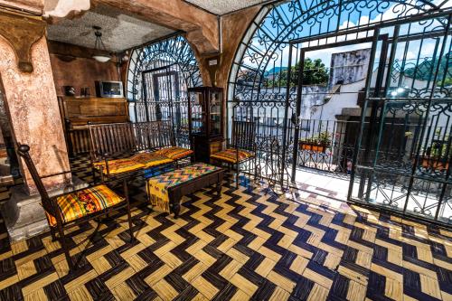 a room with several beds and a large window at Hotel La Sin Ventura in Antigua Guatemala