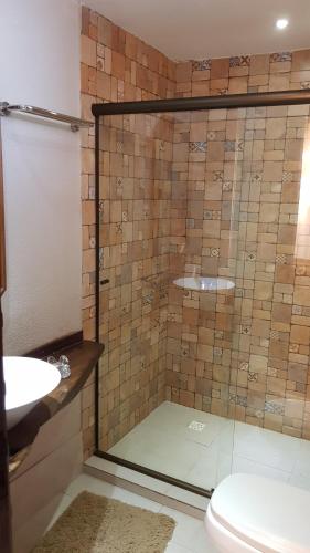 a bathroom with a shower with a toilet and a sink at GUEST HOUSE LA MANSIÓN in Foz do Iguaçu