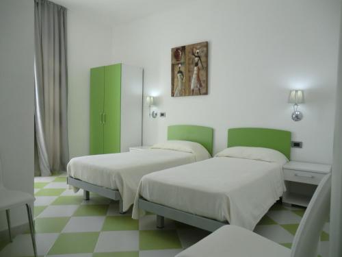 two beds in a room with green and white at Mediterraneo Mare e Sole in Marina di Palma