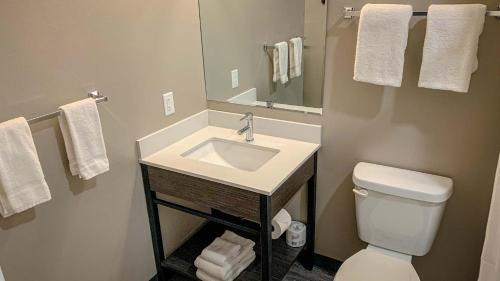 a bathroom with a sink and a toilet and a mirror at Studio 6 North Platte - East in North Platte