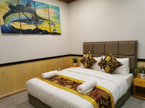 a bedroom with two beds and a painting on the wall at Ocean Vista Maldives,Maafushi in Maafushi