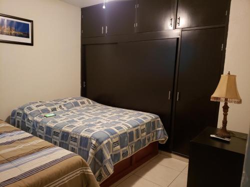 een slaapkamer met 2 bedden en een grote kast bij Departamentos Mazatlán in Mazatlán
