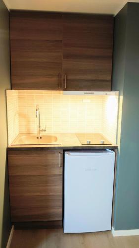 a kitchen with a sink and a white refrigerator at På Hjørnet Gjestehus in Skjervøy
