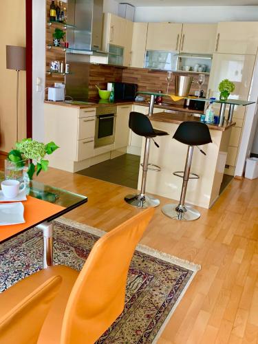 a kitchen with two chairs and a table and a counter at Luxurious city apartment incl garage and terrace in Vienna