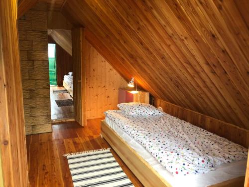 a bedroom with a large bed in a wooden room at Siedlisko Role in Role