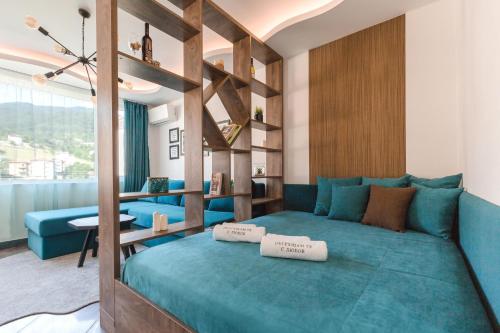 ein Schlafzimmer mit einem blauen Bett mit zwei Kissen darauf in der Unterkunft ОРФЕЕВИТЕ ПЕСНИ in Dewin