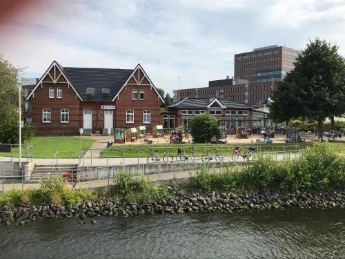 eine Gruppe von Gebäuden in einer Stadt mit einem Fluss in der Unterkunft Kanal-Haus "Das Gästehaus direkt am NOK" in Osterrönfeld