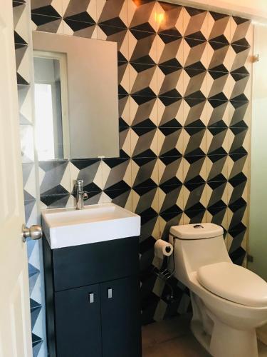 a bathroom with a toilet and a sink and a mirror at Cómodo y lindo depa con Alberca in Puerto Vallarta