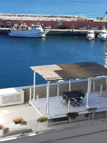 a deck with a picnic table and a boat in the water at Maridea - La Darsena in Ponza