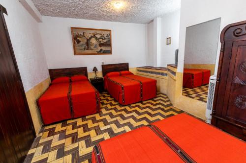 Habitación con 2 camas con cojines rojos en Hotel La Sin Ventura, en Antigua Guatemala