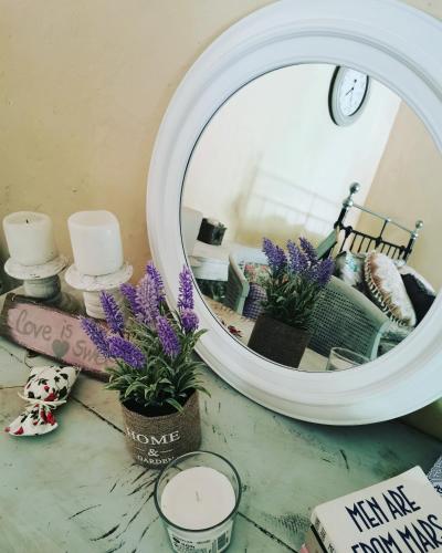 a mirror on top of a table with flowers at Holiday House Prodromos in Prodromos