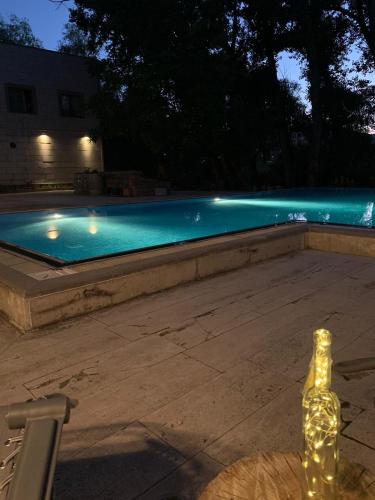 a bottle sitting next to a swimming pool at night at SUNOLUS VINEYARDHOUSe in Kayseri
