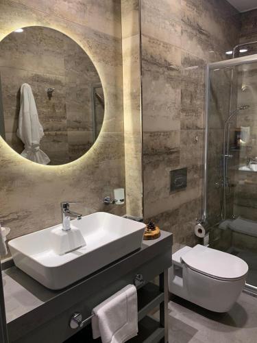a bathroom with a sink and a toilet and a mirror at SUNOLUS VINEYARDHOUSe in Kayseri