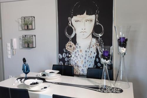 a dining room table with a picture of a woman at Jasmine - Apartment in Kalamata in Kalamata