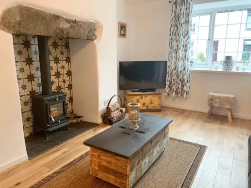 a living room with a fireplace and a tv at Gorlan Cottage Tal y Bont Conwy in Conwy